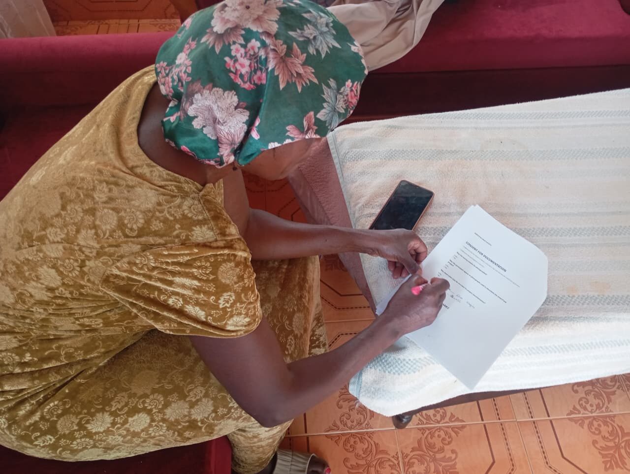Erah Chomba signing a written consent form for documentation