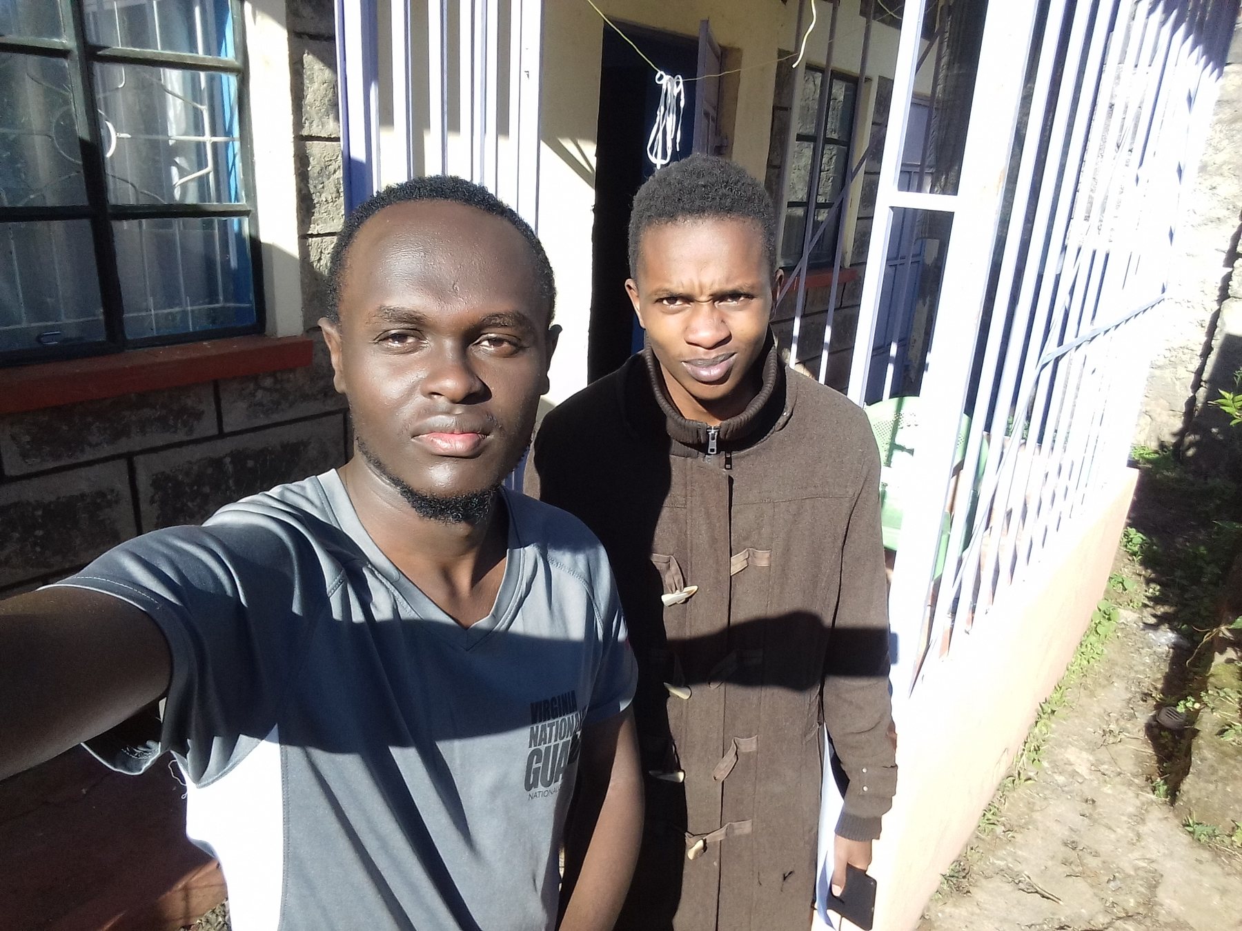 Eric Githinji (right) with GreenTrack researcher George Ngugi, outside Eric's home in Subukia